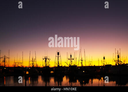 Sonnenuntergang Silhouette des angedockten Schiffe in klarem Himmel und Reflexion Stockfoto