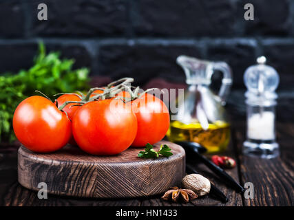 frische Tomaten an Bord und auf einem Tisch Stockfoto