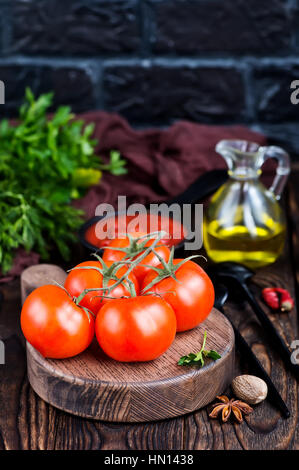 frische Tomaten an Bord und auf einem Tisch Stockfoto