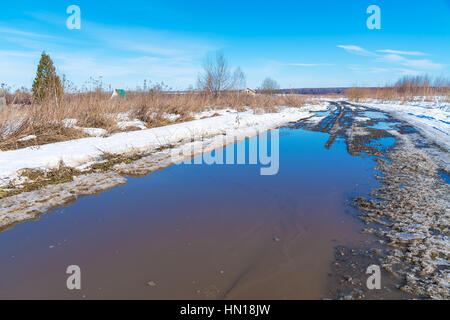 Die Straße im Frühjahr Auftauen mit Schlamm und Pfützen Stockfoto