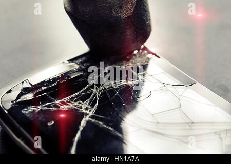 Gebrochen Handy-Bildschirm und Hammer auf Hintergrund, geknackt ein Hammerschlag auf das Handy in eine Wut, das Glas, Closeup, Wirkung, das defekte Telefon Stockfoto