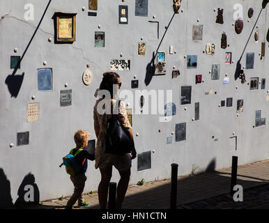 VILNIUS, Litauen - 20. August 2015: Mutter und Kind sind zu Fuß entlang Literatu Straße mit Kunstwerken an Wänden Stockfoto