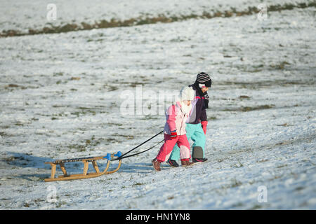 ZAGREB, Kroatien - 15. Januar 2017: Zwei Kinder ziehen den Schlitten den Berg hinauf zur Winterzeit in Zagreb, Kroatien. Stockfoto