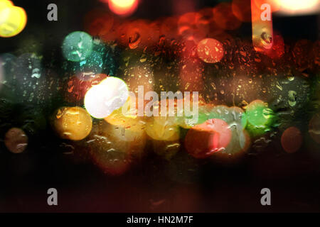 nasse Fenster mit Bokeh Nachtlichter Stockfoto