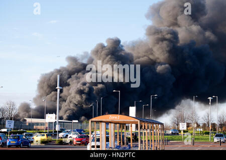 Großes Fabrikfeuer mit dicken schwarzen Rauchwolken Stockfoto