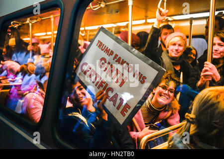 Während die Frauen März auf Washington, DC unterzeichnen eine überfüllte u-Bahn Auto mit Mann, Anti-Trump Fake Gurt hält am 21. Januar 2017 Stockfoto