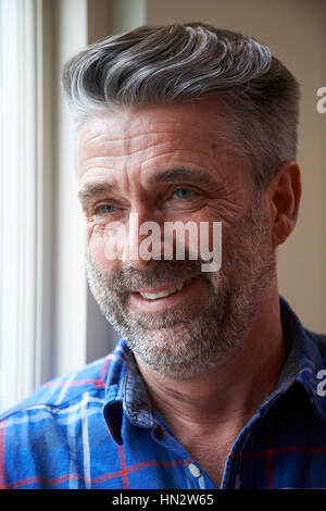 Indoor-Kopf und Schultern Portrait Of Smiling reifen Mann Stockfoto
