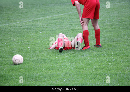 Teamkollege mit verletzten Spieler beim Fußballspiel Stockfoto