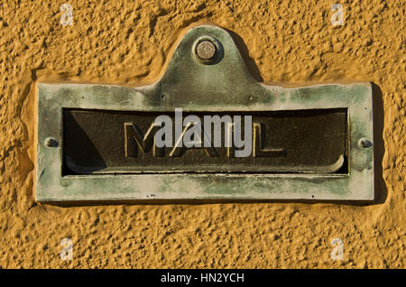Vintage Tür Mailslot an der Wand von gelber Farbe. Stockfoto
