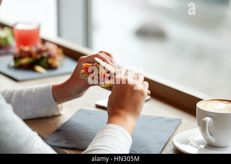 Frau essen Lachs Panini Sandwich Restaurant Stockfoto