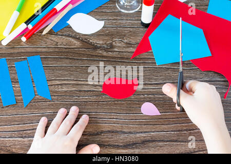 Das Kind schneidet Papier Details. Das Kind erstellen eine Frühling Grußkarten-Papier. Von hand gefertigt. Fertige für Kinder. Kinder Art Project, Handarbeiten, cra Stockfoto