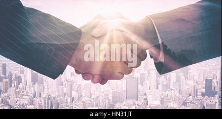 Geschäftsleute Händeschütteln gegen Sonnenaufgang über Berge Stockfoto