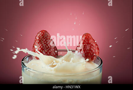 Erdbeer Milchshake mit Splash isoliert auf rosa Stockfoto