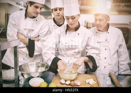 Kulinarischen Studenten lernen, wie man Teig in Küche zu mischen Stockfoto