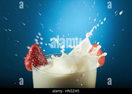 Milch-Drop von Splash auf blauem Hintergrund isoliert Stockfoto