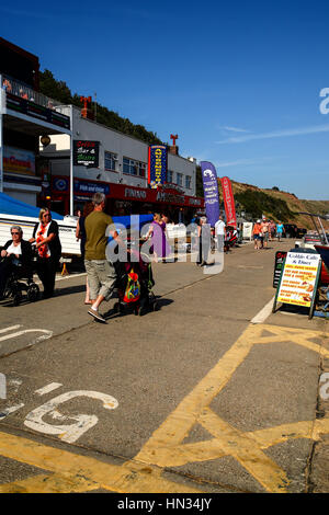 Touristen, die zu Fuß auf die gepflasterte Landung bei Filey Bay North Yorkshire England UK Stockfoto