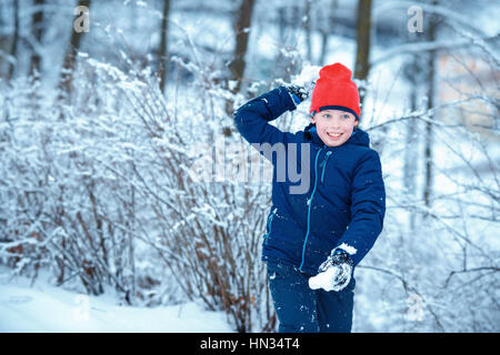 Niedlichen kleinen Jungen Spaß mit Schneeball Kampf winter Stockfoto