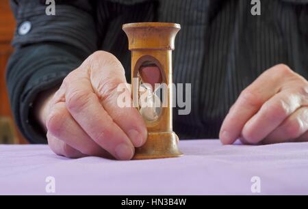 Ältere Frau hält eine Sanduhr mit ihren Händen Stockfoto
