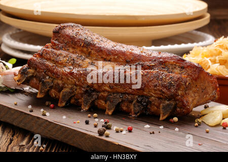 Gebratene Schweinerippchen mit Kräutern auf hölzernen Hintergrund Stockfoto