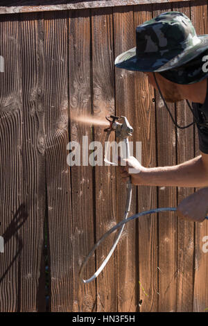 Professionelle Maler Haus Garten Zaun mit Beize sprühen. Stockfoto