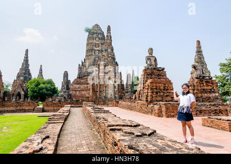 Touristischen Teenager-Mädchen zeigen Hand einladend, Wat Chaiwatthanaram zu besuchen ist alten buddhistischen Tempel, berühmten und wichtigen touristischen Attraktion religion Stockfoto