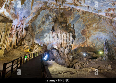 Boardwalk durch beleuchtete Tropfsteinhöhle, Stalaktiten und Stalagmiten, Thiên Đường Höhle Stockfoto