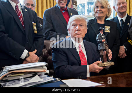 Washington DC, USA. 7. Februar 2017. US-Präsident Donald Trump hält eine Statue, die er als Geschenk beim Treffen mit county Sheriffs im Oval Office des weißen Hauses in Washington, DC, USA, am Dienstag, 7. Februar 2017 erhalten. Die Trump-Verwaltung kehren zum Gericht Dienstag um zu argumentieren, dass es hat weitreichende Befugnisse über Staatssicherheit und auf Nachfrage Wiedereinstellung der ein Reiseverbot für sieben mehrheitlich muslimischen Ländern, die Flüchtlinge gestrandet, Proteste ausgelöst und übergab die junge Regierung seine erste Zerreißprobe. Bildnachweis: MediaPunch Inc/Alamy Live-Nachrichten Stockfoto