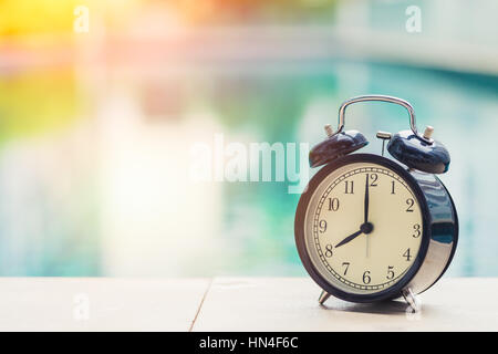 08:00 Retro-Uhr um den Swimmingpool im freien Zeit Ferienkonzept. Stockfoto