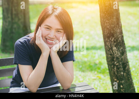 Einzelnen asiatischen Frauen teen cute kurze Haare freundlich Smiley im Green Park entspannen und Lächeln. Stockfoto