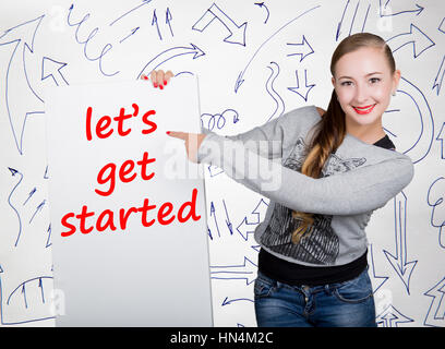 Junge Frau mit Whiteboard mit dem Wort schreiben: Lasst uns loslegen. Technik, Internet, Wirtschaft und Marketing. Stockfoto
