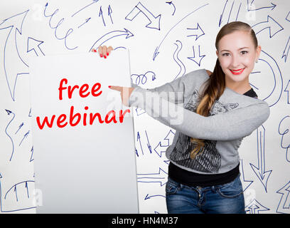 Junge Frau mit Whiteboard mit dem Wort schreiben: kostenloses Webinar. Technik, Internet, Wirtschaft und Marketing. Stockfoto