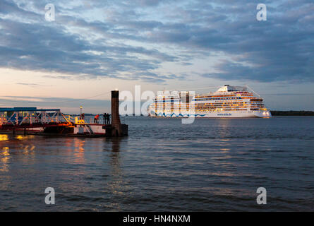 Stade, Deutschland - 19. September 2015: Kreuzfahrtschiff AIDAbella vorbei an der Pier von Stade an der Elbe in der Abenddämmerung. Menschen auf dem Pier beobachten der Abteilung Stockfoto