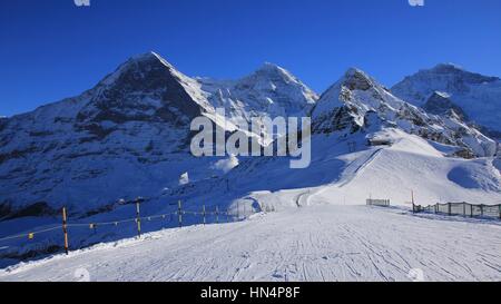 Winter-Szene in Grindelwald. Ski-Pisten und Schnee bedeckt Mountaind Eiger, Monch, Lauberhorn und Jungfrau. Stockfoto