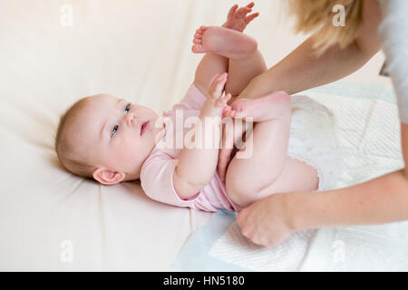 Mutter ändert die Windel Baby Tochter Stockfoto