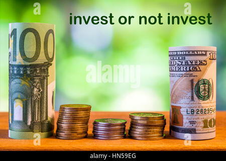Hundert Euro und 100 US-Dollar rollte Rechnungen Banknoten, mit Euro-Münzen und amerikanischen Cent auf grüne unscharfe Bokeh Hintergrund. Investment co Stockfoto