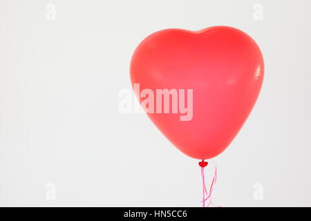 Herzförmige rote Ballon vor weißem Hintergrund Stockfoto