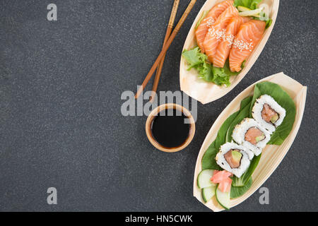 Sushi auf Boot geformte Platte mit Stäbchen und sauce Stockfoto