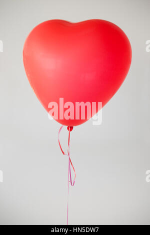 Herzförmige rote Ballon vor weißem Hintergrund Stockfoto