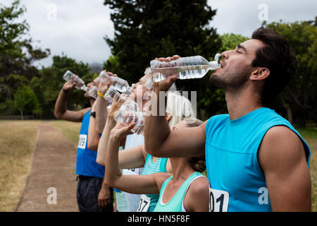 Sportler trinken Wasser im Park am sonnigen pro Tag Stockfoto