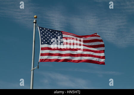 Star Spangled Banner vor dem blauen Himmelshintergrund fliegen. Stockfoto