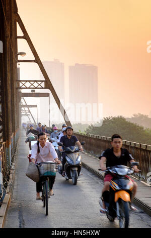 Rauchiger, verschmutzter Himmel und starker Pendler-Motorradverkehr auf der Long Bien Freischwinger-Brücke, Hanoi, Vietnam Stockfoto