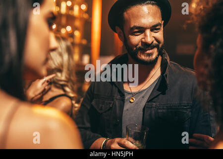 Hübscher junger Mann mit Party mit Freunden im Nachtclub. Junge Menschen im Pub, die gute Zeit. Stockfoto