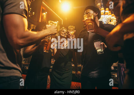 Gruppe von Freunden, die Getränke an der bar zusammen. Junge Menschen im Nachtclub mit Cocktails genießen. Stockfoto