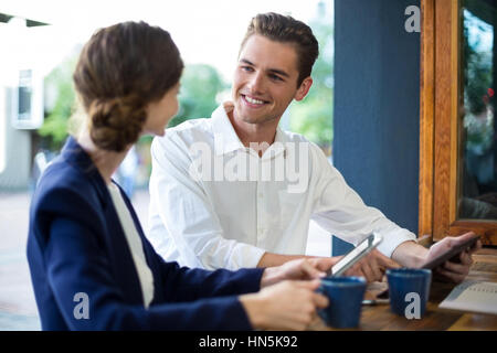 Geschäftsmann und Frau Interaktion beim Kaffeetrinken am Schalter im CafÃƒÂ © Stockfoto