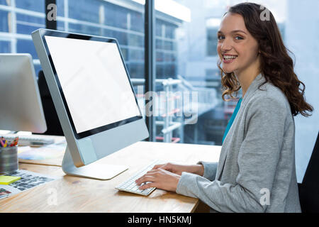 Porträt von weiblichen Grafik Designer arbeiten über Computer am Schreibtisch im Büro Stockfoto