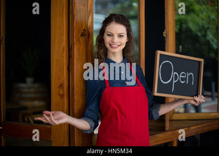 Porträt von lächelnden Kellnerin mit Tafel vor dem Café stehen Stockfoto