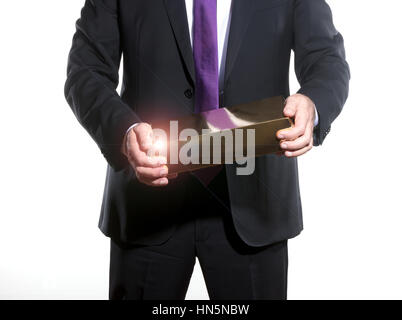 erfolgreicher Geschäftsmann mit einem großen Goldbarren Stockfoto