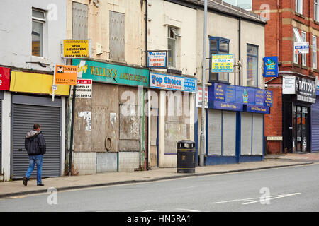 Ein geschlossener Überblick und verschalten von Windows unabhängigen Geschäfte auf einer terrassenförmig angelegten Straße im Stadtzentrum von Bolton, Lancashire, England, UK Stockfoto