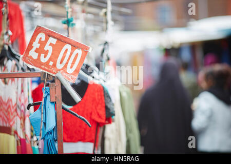 Billig zu kleiden und £5 Pfund-Zeichen auf einem Markt hängen stall unabhängige Einzelhändler auf Longsight Markt Manchester, England, UK Stockfoto