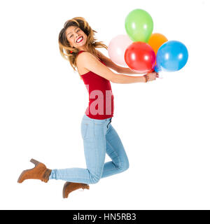 Schöne Frau mit rotem Hemd springen mit bunten Luftballons, die isoliert auf weißem Hintergrund Stockfoto
